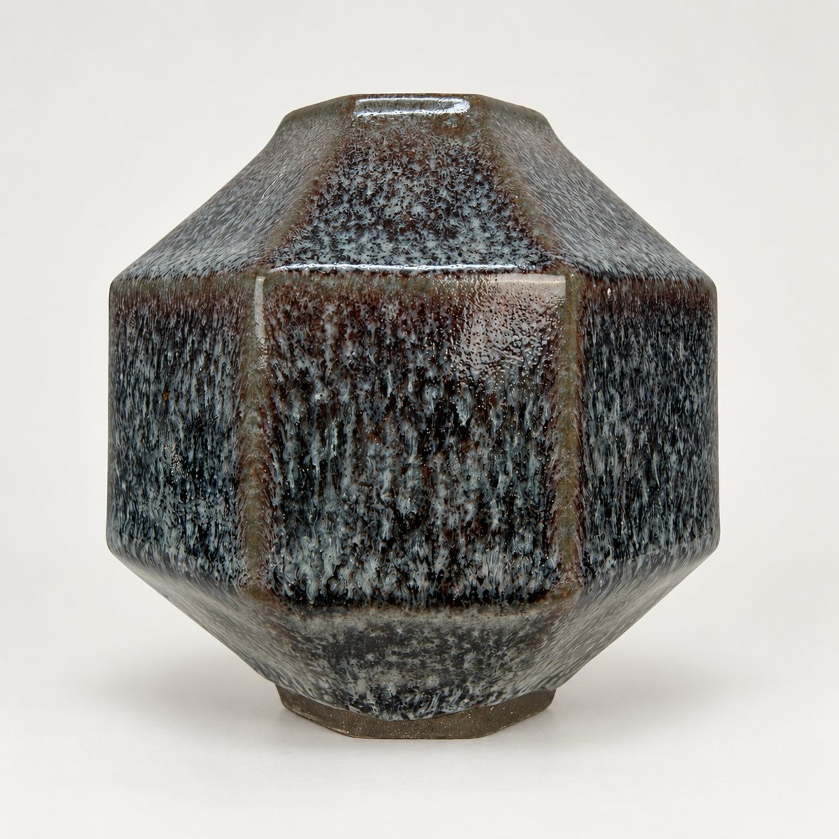Octagonal pot, blue-grey oil-spot glaze breaking rust at the edges over an unglazed foot